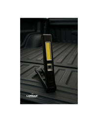 Black LED work light on a black truck bed with Lumnar branding.
